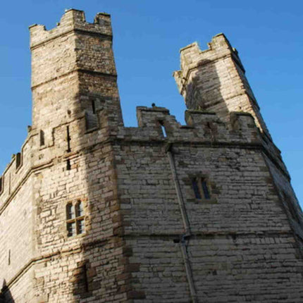 Caernarfon castle's Eagle tower set against a blue sky