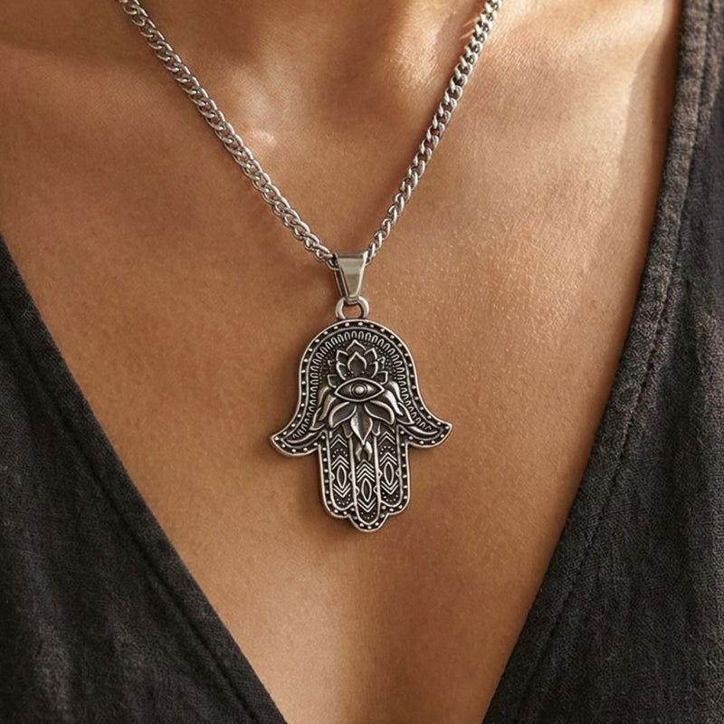 close image of a woman wearing a Hand of Fatima charm pendant on a necklace