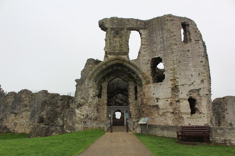 The great gatehouse of Denbigh Castle, its arched entrance and towers, seen from the approach path, October 2026
