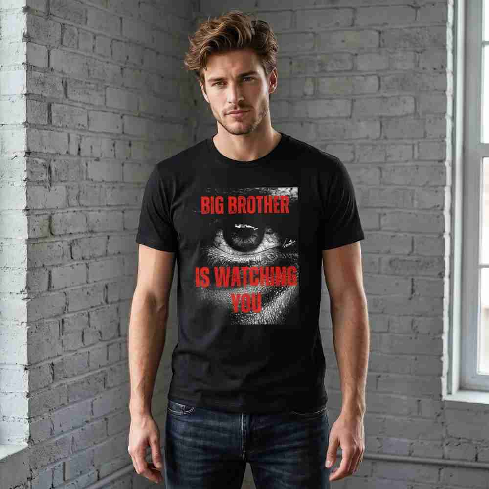 Man wearing a black t-shirt with 'Big Brother is Watching You' design against a brick wall.