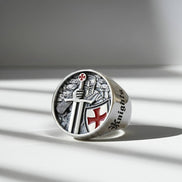 Silver ring with intricate design on a light surface