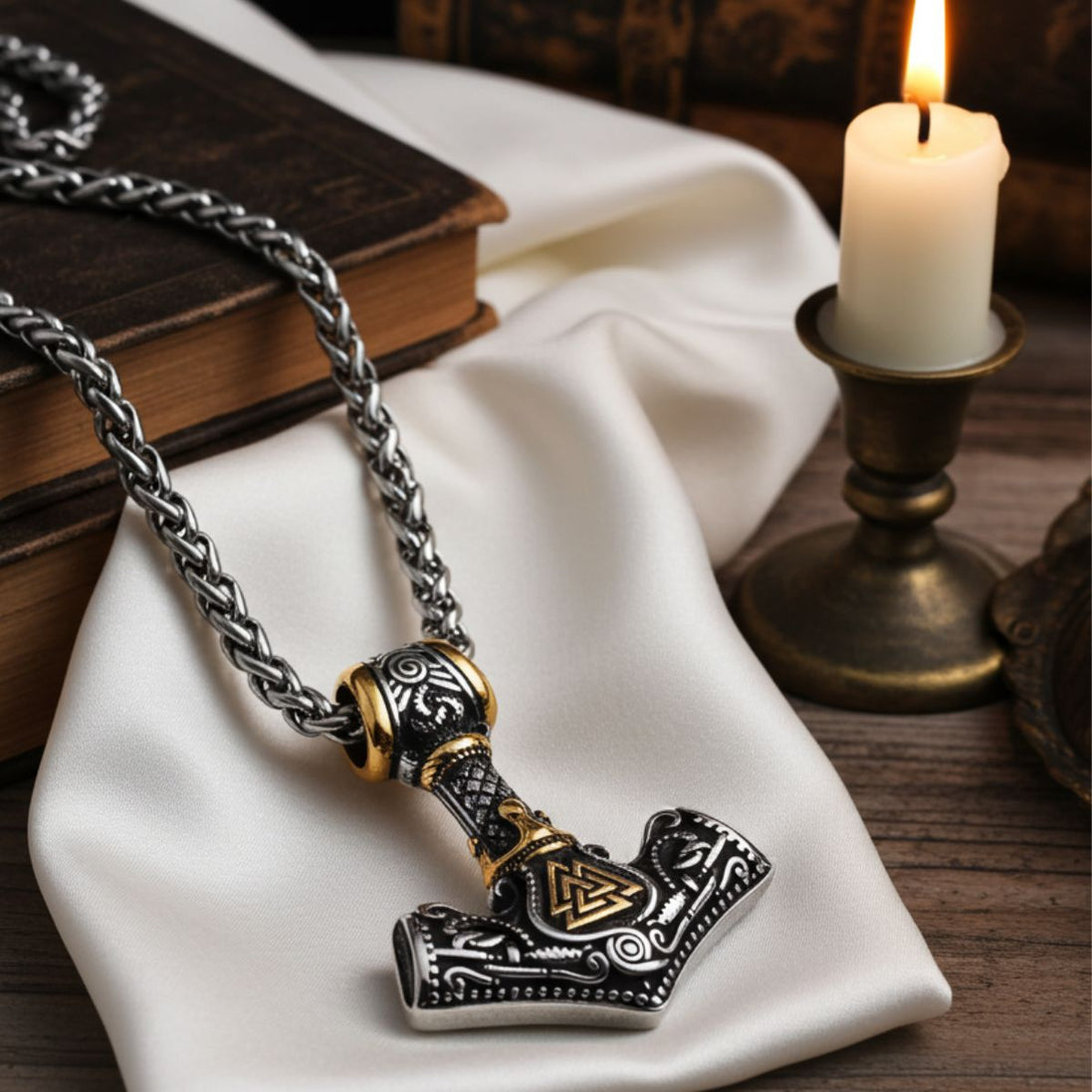 Viking-style necklace with hammer pendant on a white cloth with a candle in the background