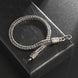 Silver braided bracelet with intricate designs on a textured black surface