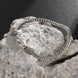 Silver bracelet with intricate design on a stone surface