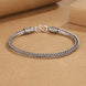 Silver braided bracelet on a brown background