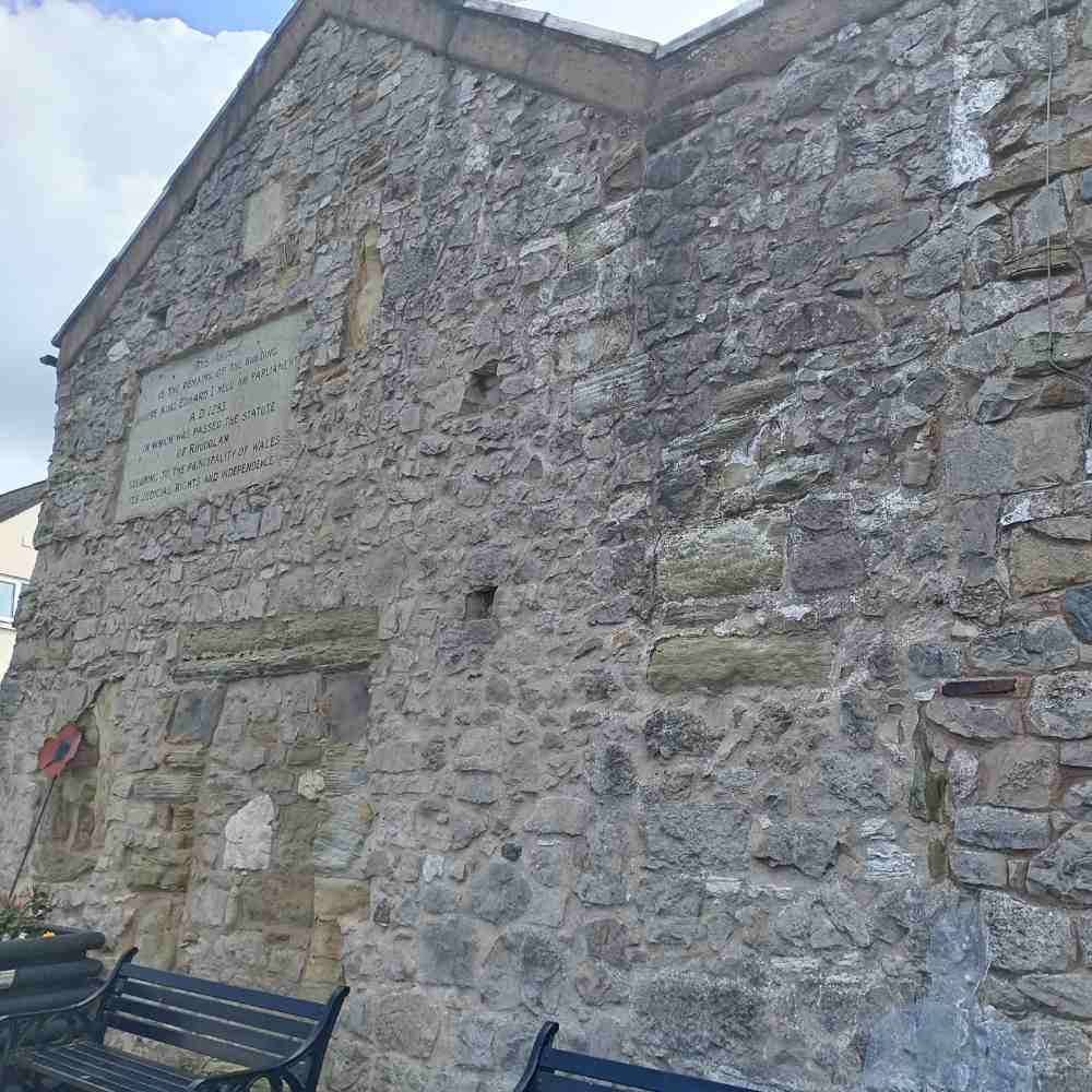 Gable wall of Parliament House, Rhuddlan, with its inscribed stone and benches in front