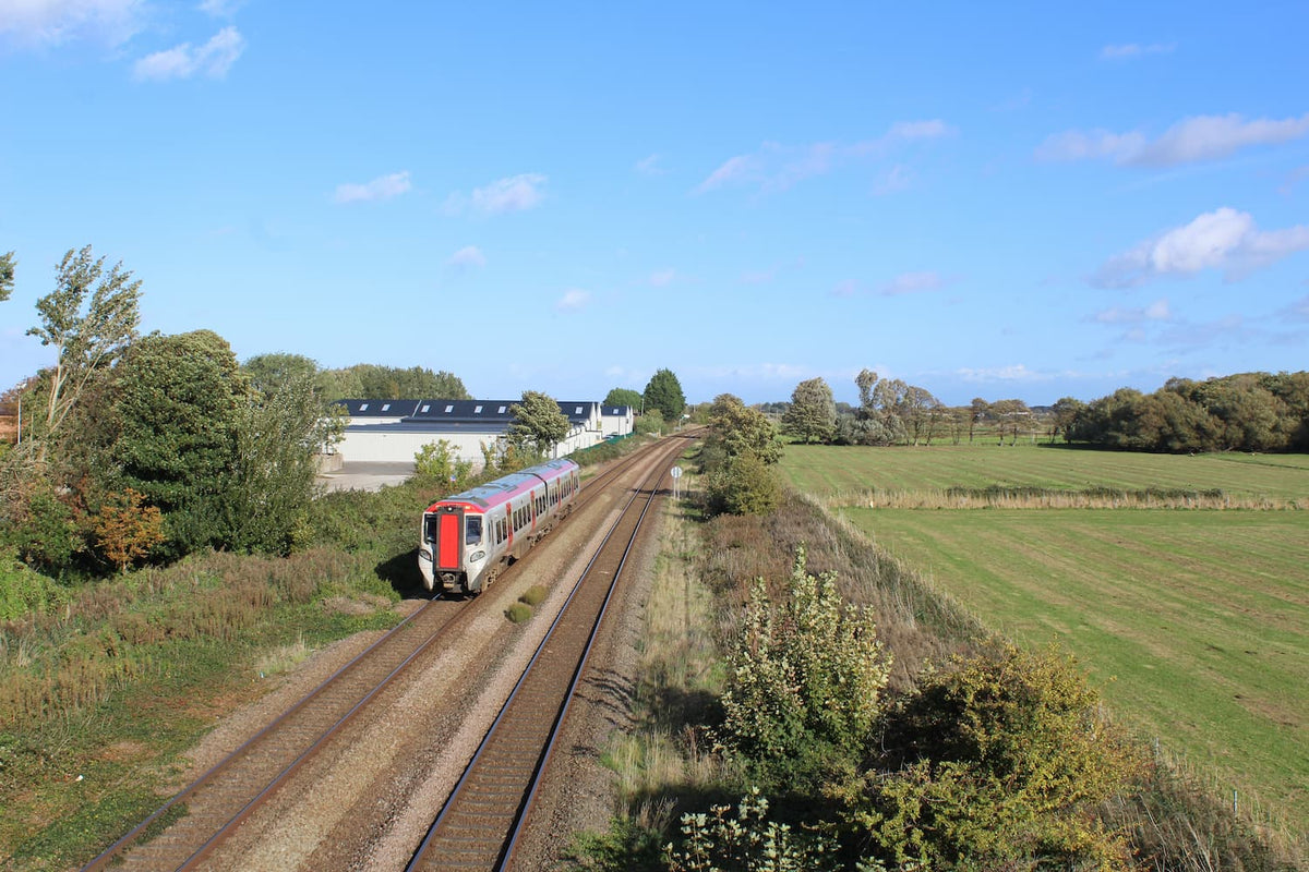Prestatyn Castle mound beside the railway line with a train passing