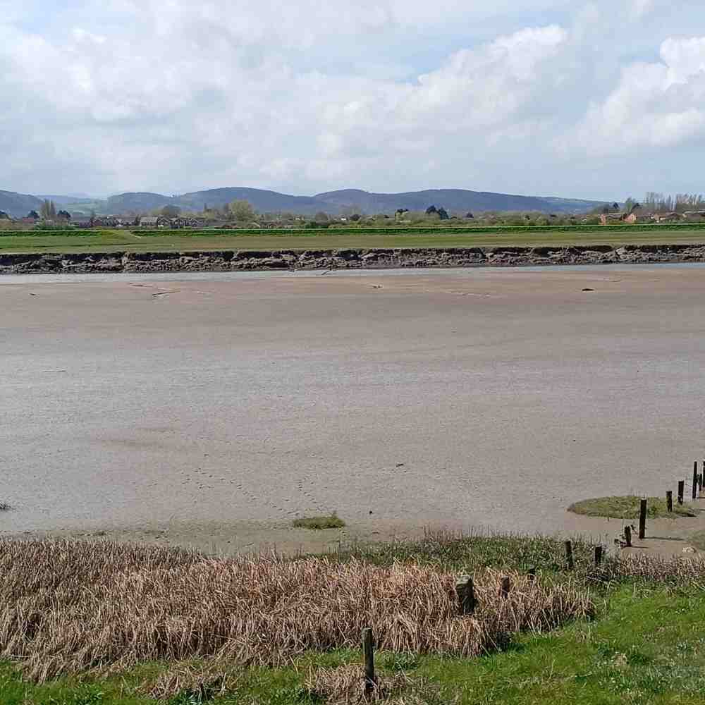 The River Clwyd at low tide below Rhuddlan, with hills beyond