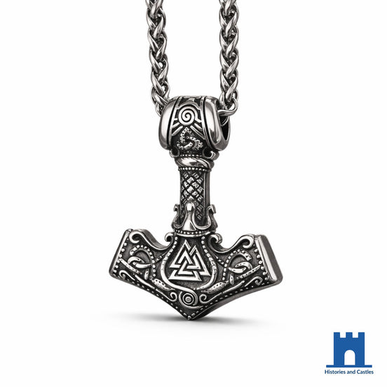 Mjolnir pendant necklace in oxidised 316L stainless steel with raised Valknut at hammer centre, Norse knotwork border, diamond-pattern handle and sculpted skull bail