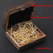 Wooden jewelry box with black interior and natural wood silk, on a dark background.