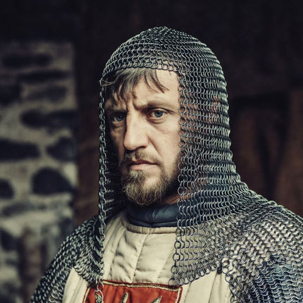 William the Conqueror in chainmail armor with a stone wall background