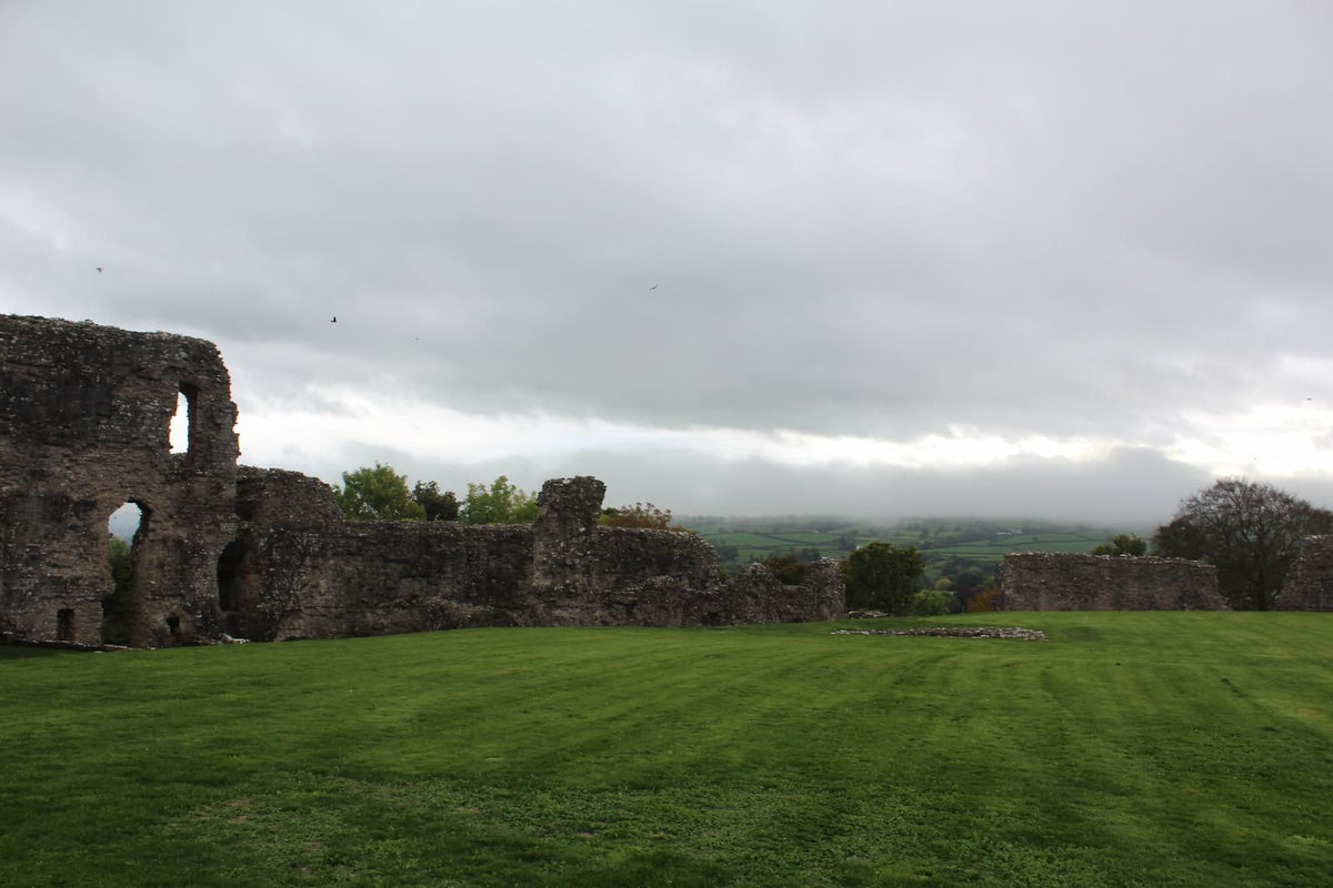 Inner ward walls of Denbigh Castle with the misty hills of the Vale of Clwyd beyond, October 2026