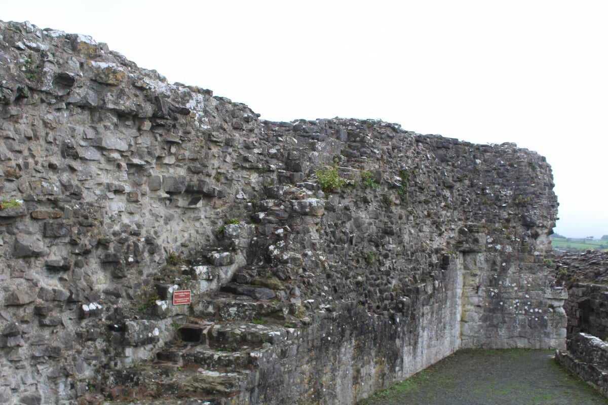 Worn stone staircase climbing the curtain wall at Denbigh Castle towards the wall walk, October 2026