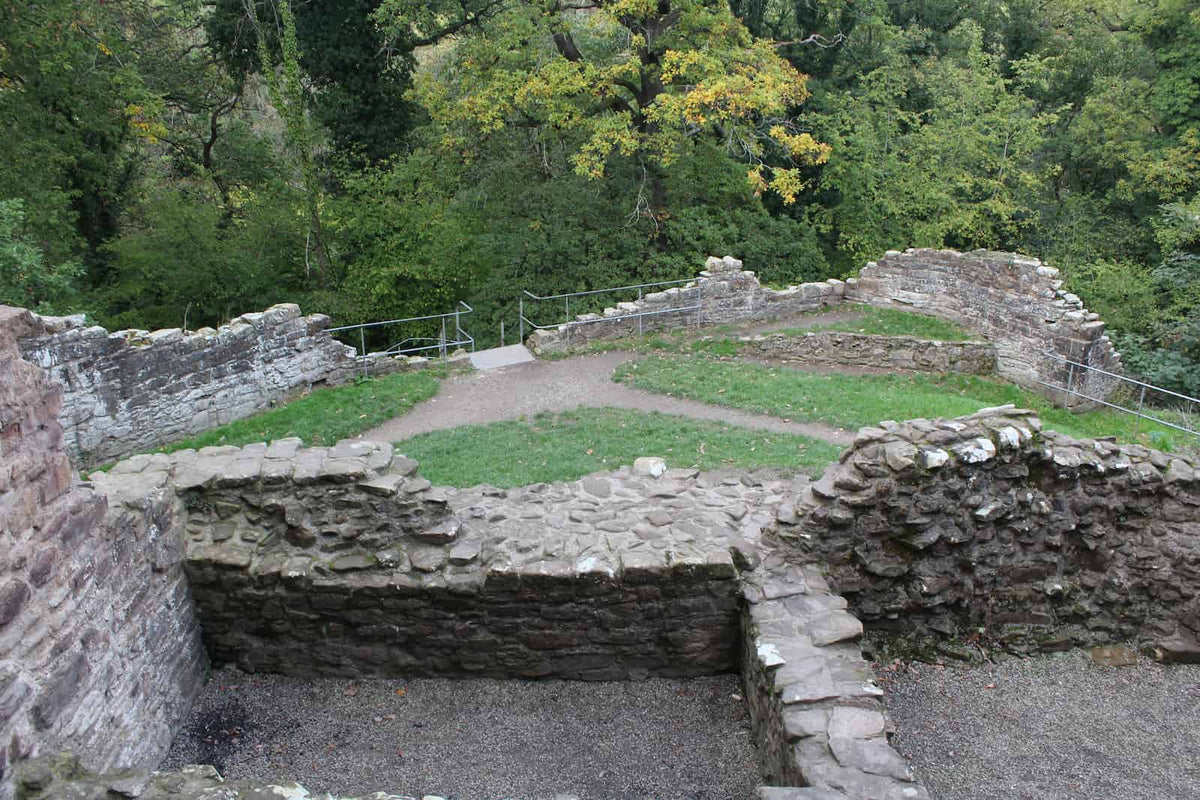 View over the upper ward walls of Ewloe Castle from the Welsh Tower, with Wepre woods beyond, October 2026
