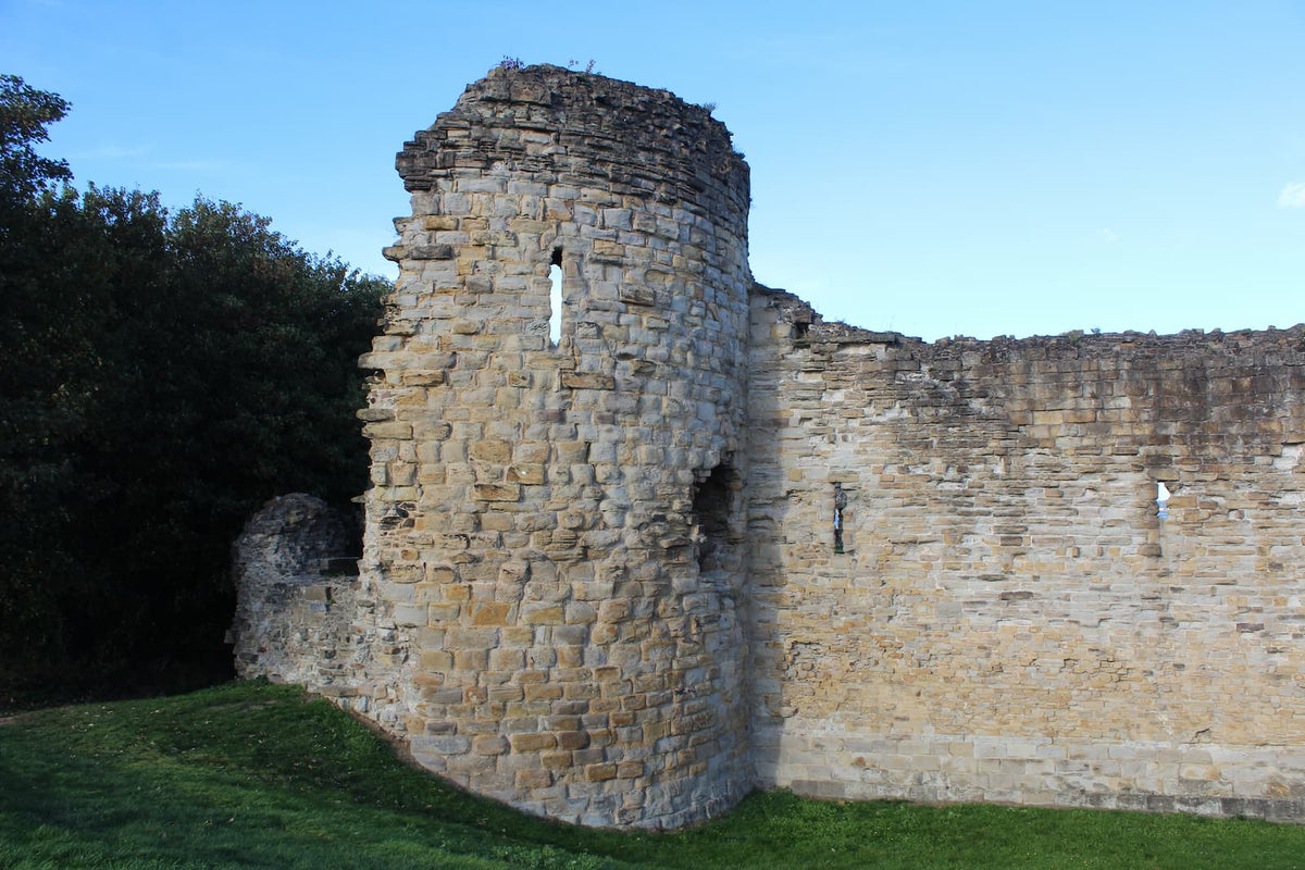 A round corner tower and the curtain wall of Flint Castle, October 2026