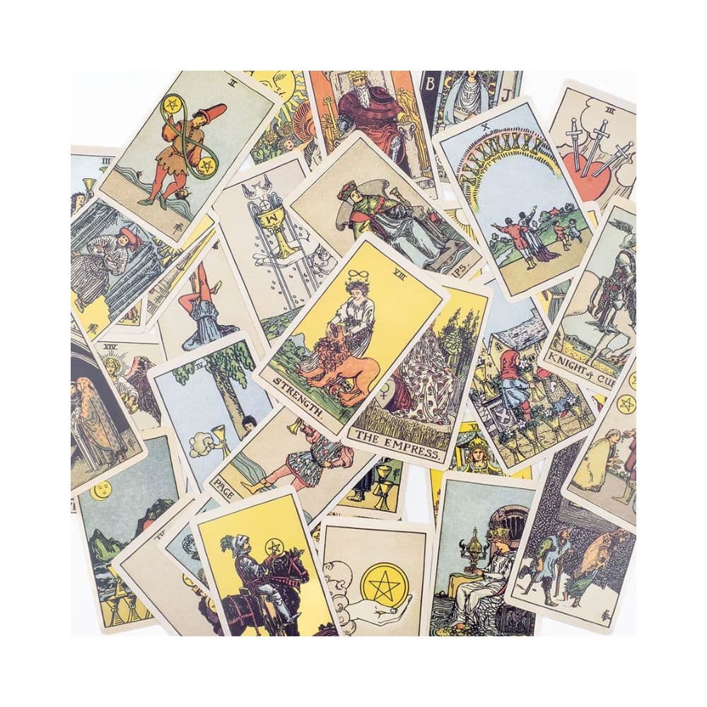 A pile of illustrated fortune telling tarot cards spread out on a white background, showing various classic card designs and colors.