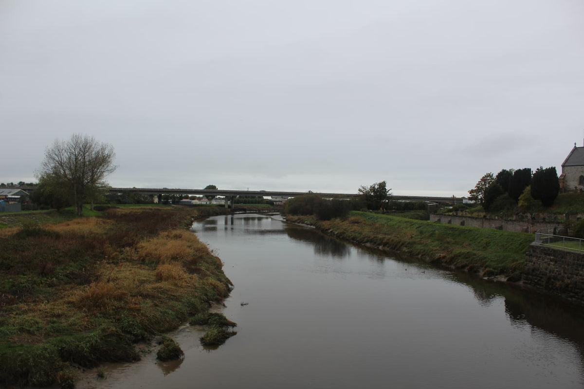 The straight channel of the River Clwyd at Rhuddlan looking towards the road bridge