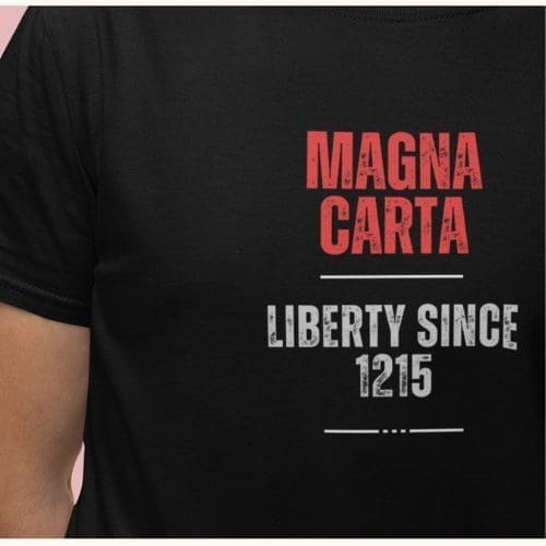 Close-up of a Magna Carta Liberty Since 1215 T-shirt, featuring MAGNA CARTA in bold red and LIBERTY SINCE 1215 in crisp white on the front.