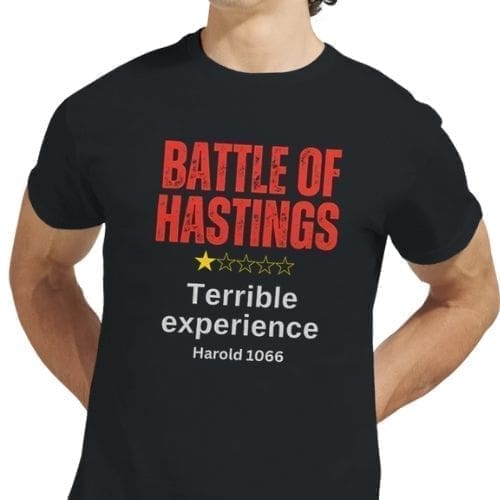 A person wears the Battle of Hastings Joke T-Shirt for History Buffs in black, with bold red BATTLE OF HASTINGS text, a one-star rating below, and Terrible experience Harold 1066 in white.