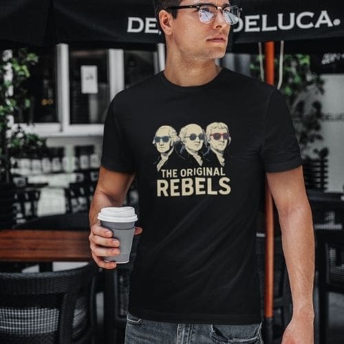 The Original Rebels – Founding Fathers Graphic T-Shirt: Black tee with three Founding Fathers wearing sunglasses and THE ORIGINAL REBELS printed boldly below the illustration.