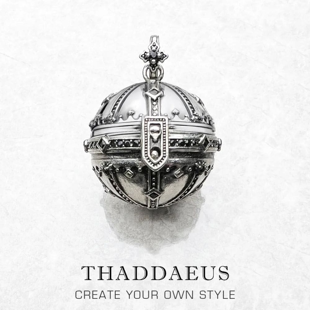 A detailed silver Pendant Kingdom of Dreams Orb with ornate designs and a clasp, displayed on white marble. Below, the text reads: THADDAEUS CREATE YOUR OWN STYLE, inspired by the Pendant Kingdom of Dreams Orb.