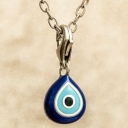 A close-up of a silver chain necklace showcases the Turkish Eye Culture Charm Pendant, a teardrop-shaped blue charm with white and light blue concentric circles and a black dot at the center.