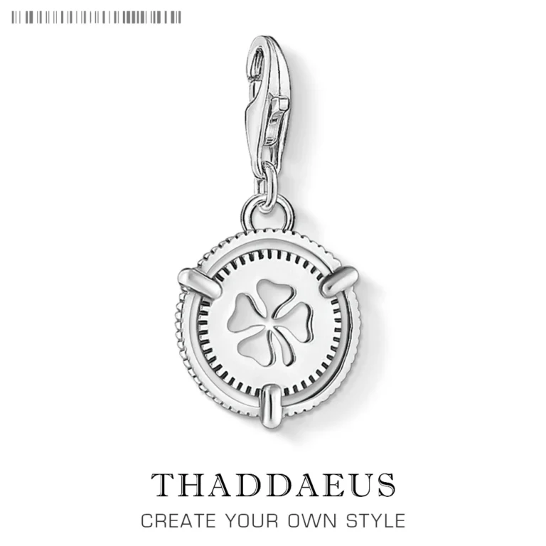 The Lucky Clover Dangle Charm Pendant features a silver clover cutout center and lobster clasp, with THADDAEUS and CREATE YOUR OWN STYLE branding below the pendant.
